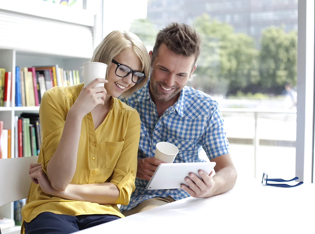 a man and a woman looking at a tablet